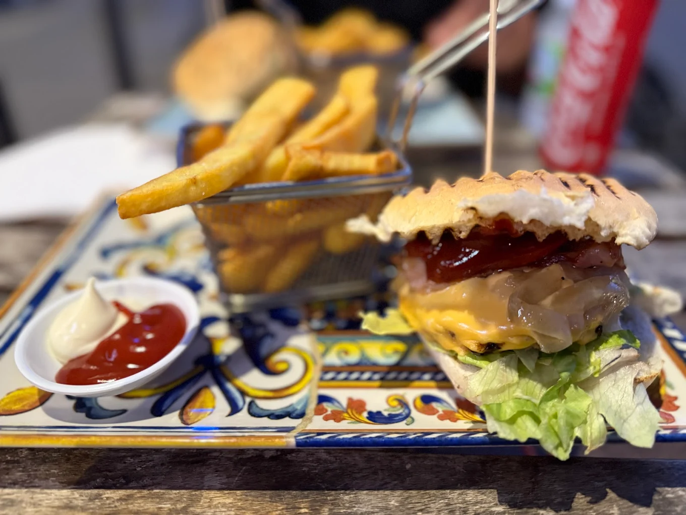 Cheeseburger con bacon e cipolla caramellata con patatine nel cestello